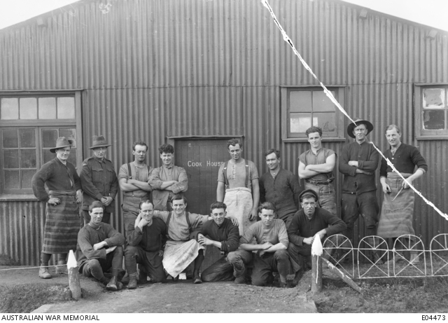 Unidentified Australian Veterinary Hospital cookhouse staff outside a corrugated-iron building at Calais.
