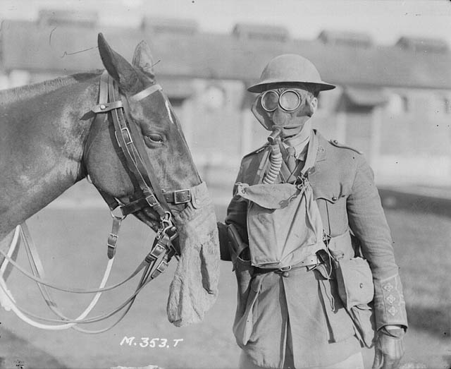 A soldier and horse wearing gas masks at Canadian Army Veterinary Corps headquarters, Shorncliffe, England, c. 1916. A posed photograph of protective equipment.